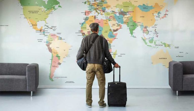 1140-man-looking-at-world-map-on-wall-esp